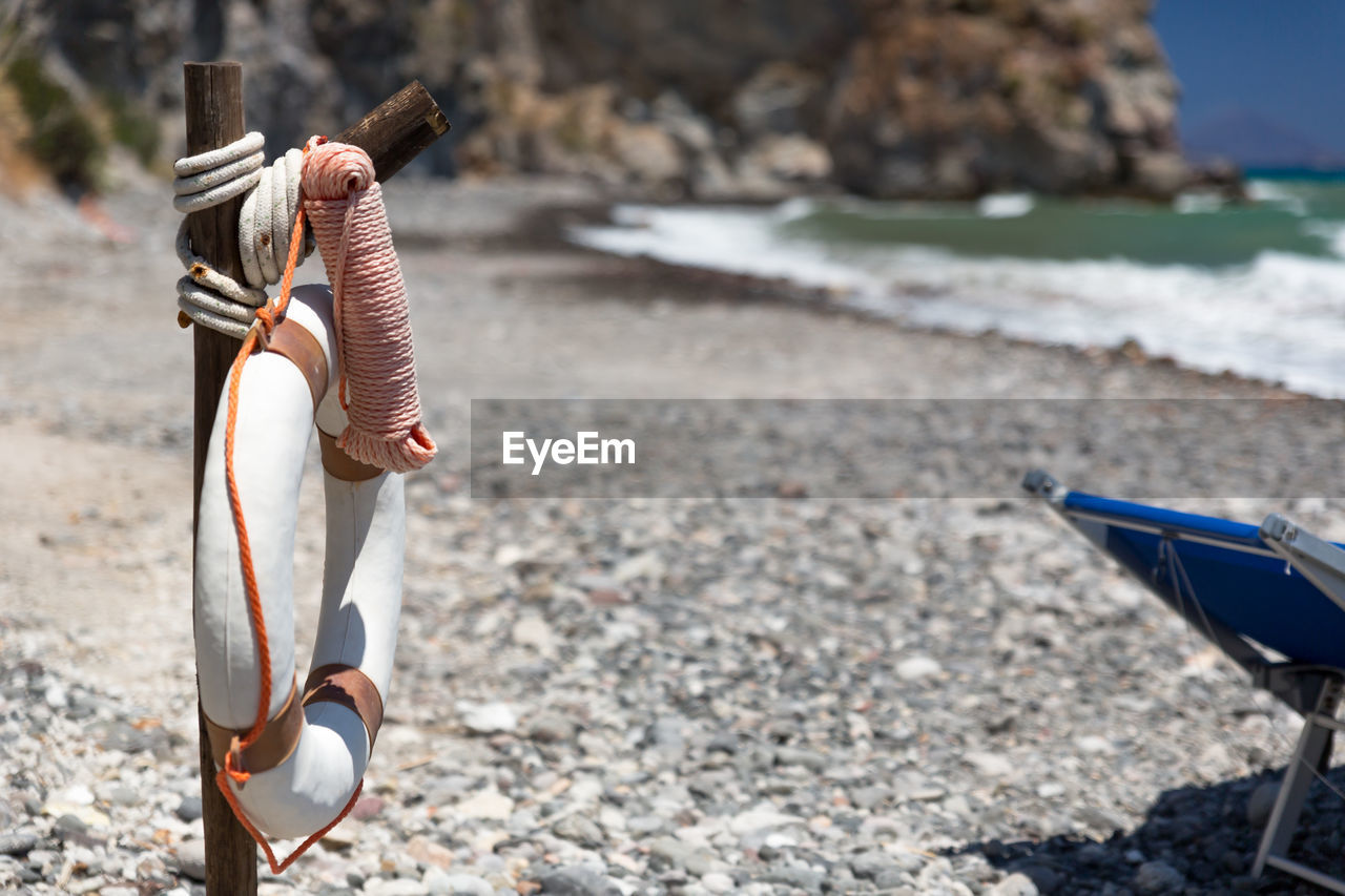 Close-up of life belt hanging on wooden post