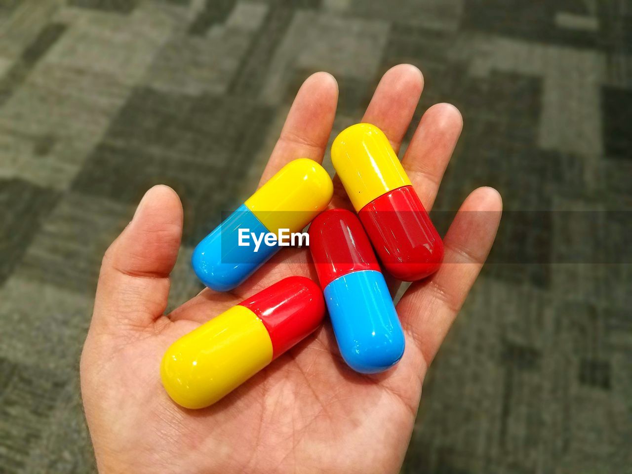 Cropped hand holding artificial capsules