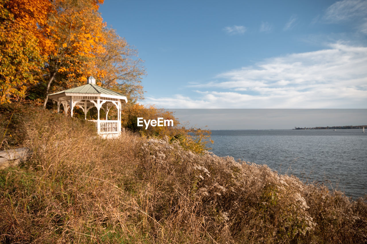 BUILT STRUCTURE BY SEA AGAINST SKY AND BUILDINGS