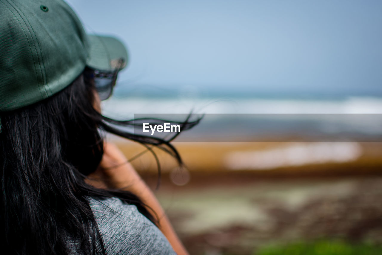 Rear view of woman wearing cap against sea