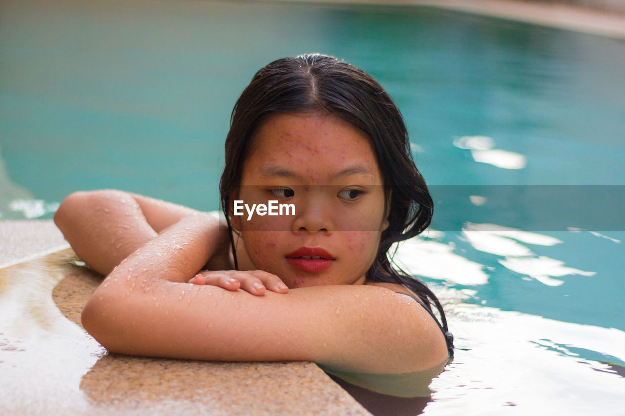 Portrait of asian woman standing on the edge of pool