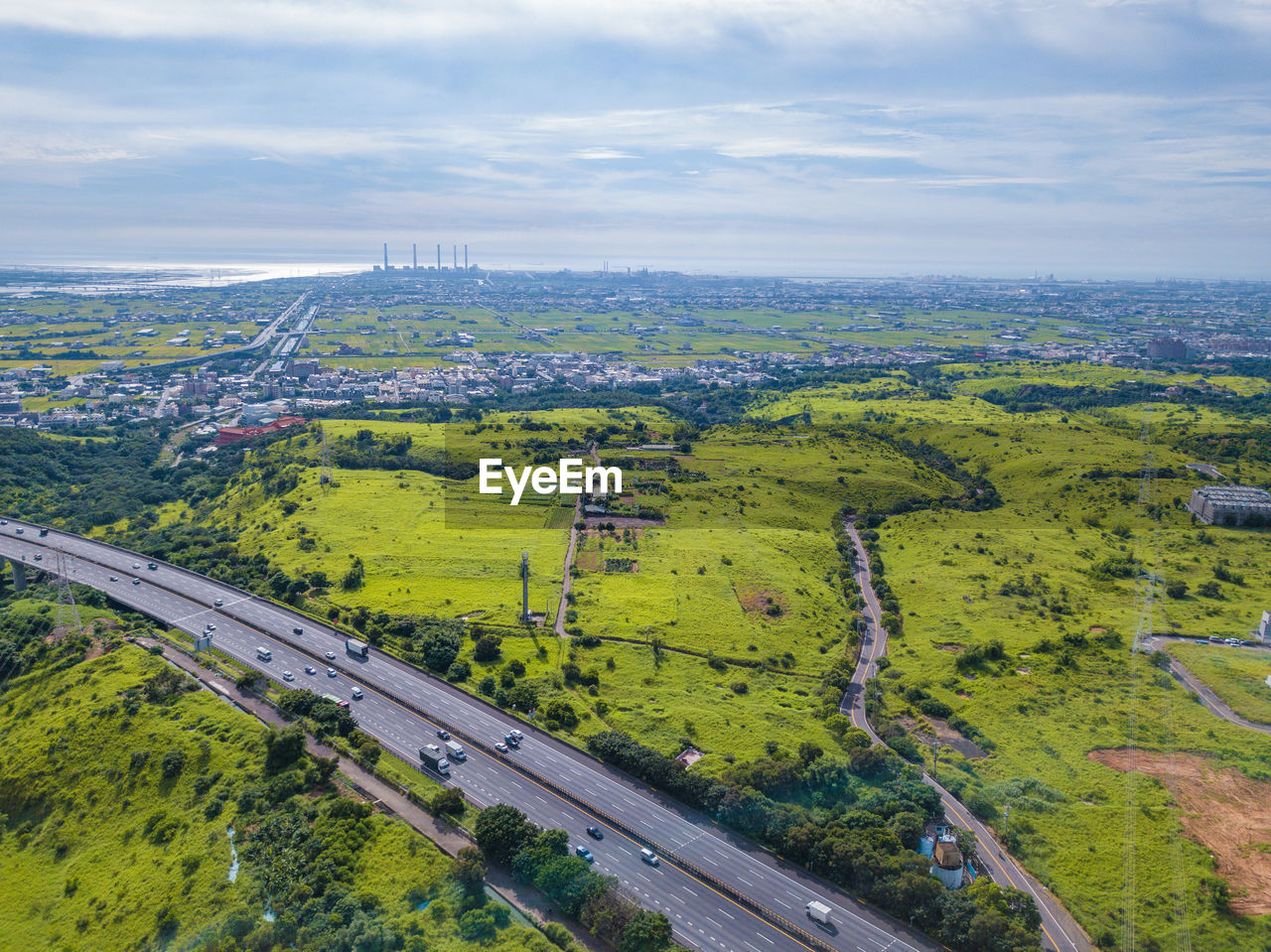 High angle view of road amidst field against sky