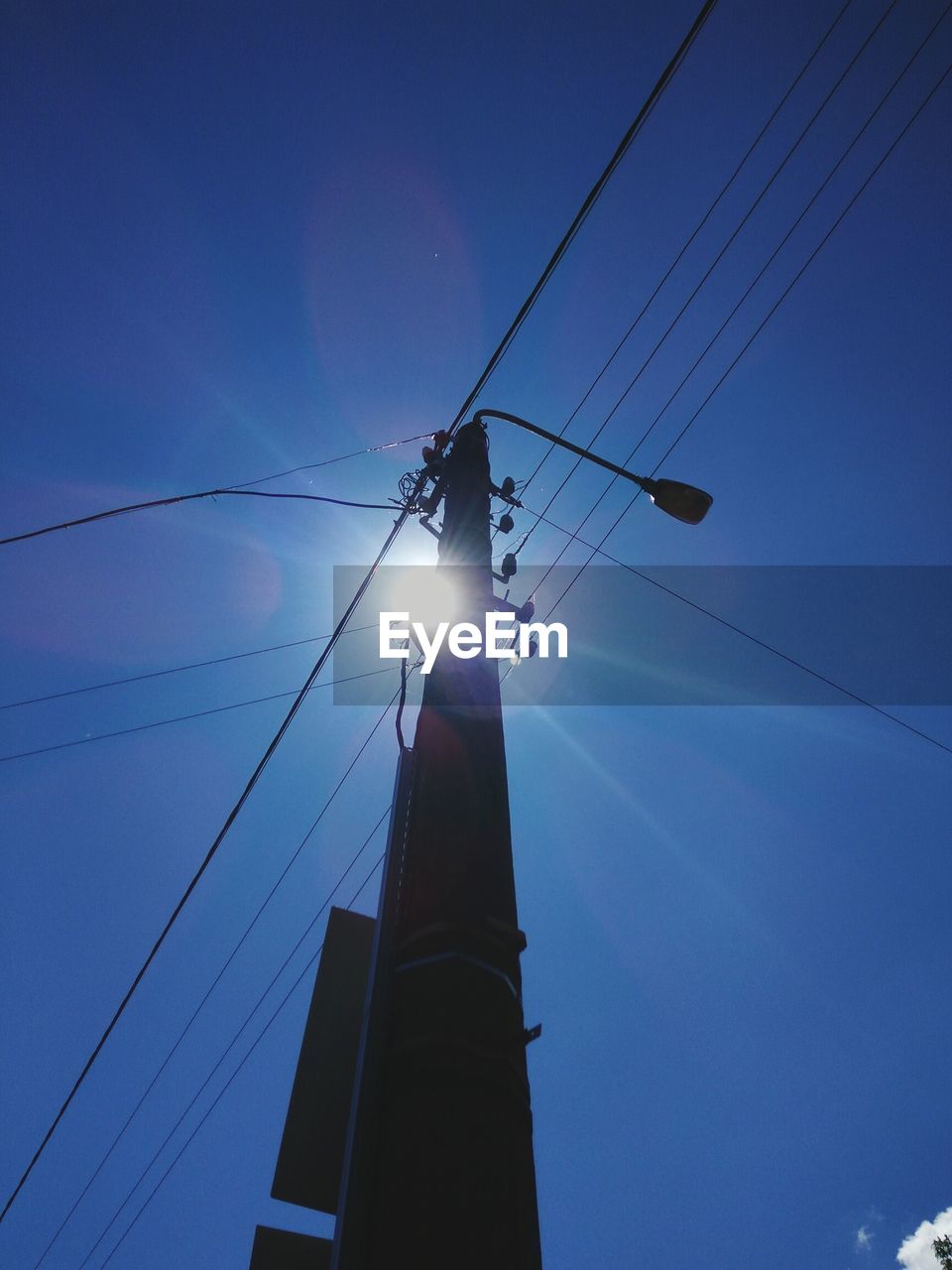 LOW ANGLE VIEW OF ELECTRICITY PYLONS AGAINST BLUE SKY