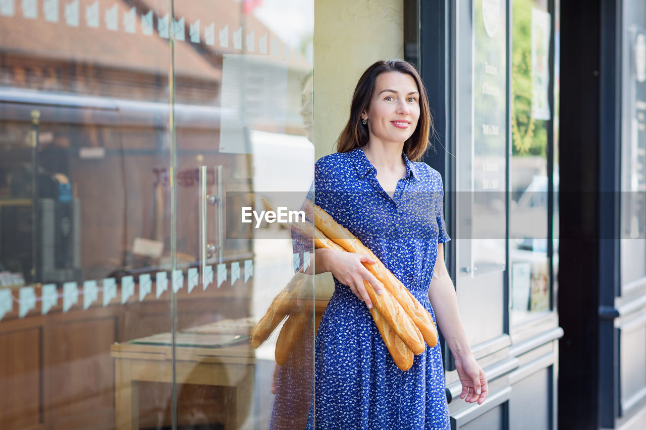 Young woman buying a french baguette