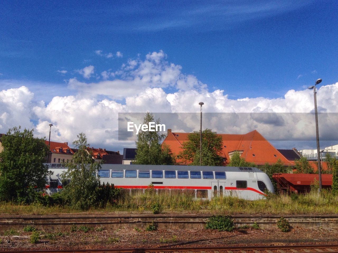 High speed train on railroad track against cloudy sky