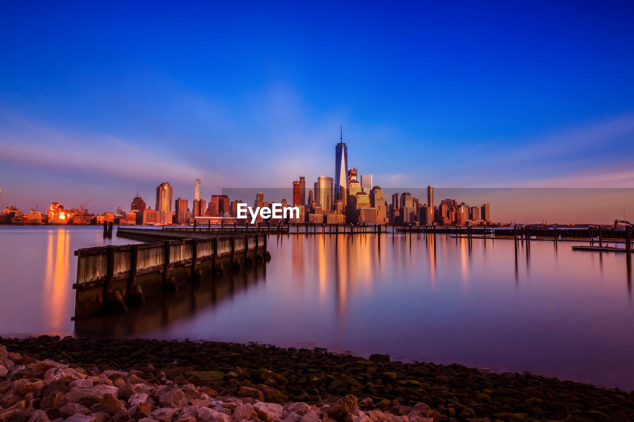 View of city at waterfront during sunset