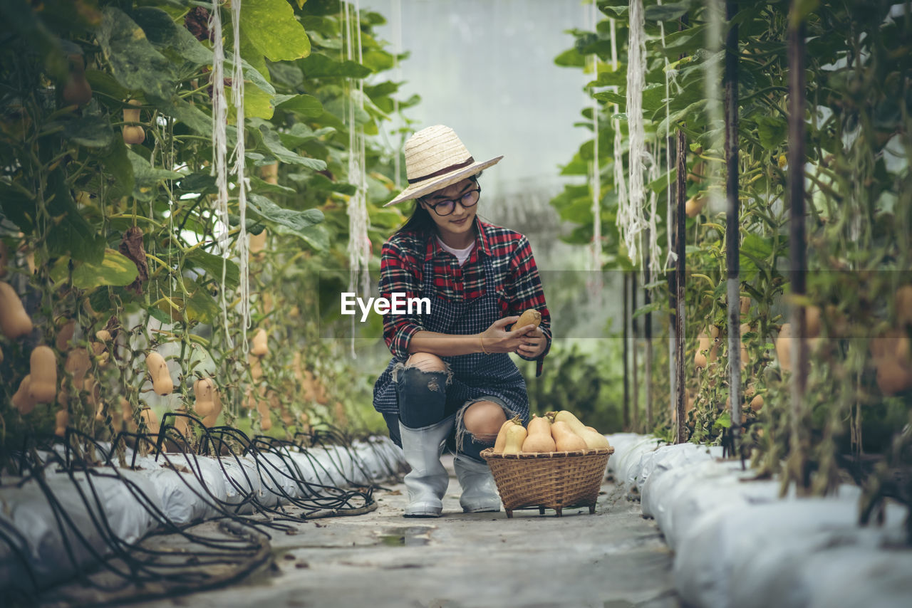 FULL LENGTH OF SMILING MAN SITTING BY BASKET