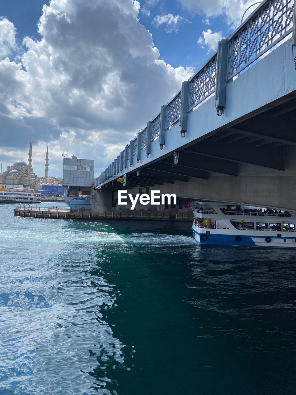 NAUTICAL VESSEL ON SEA BY BUILDINGS AGAINST SKY