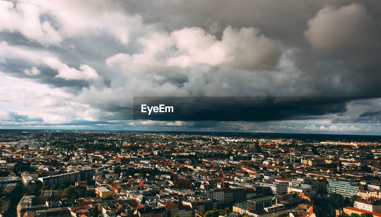 Aerial view of cityscape against storm clouds