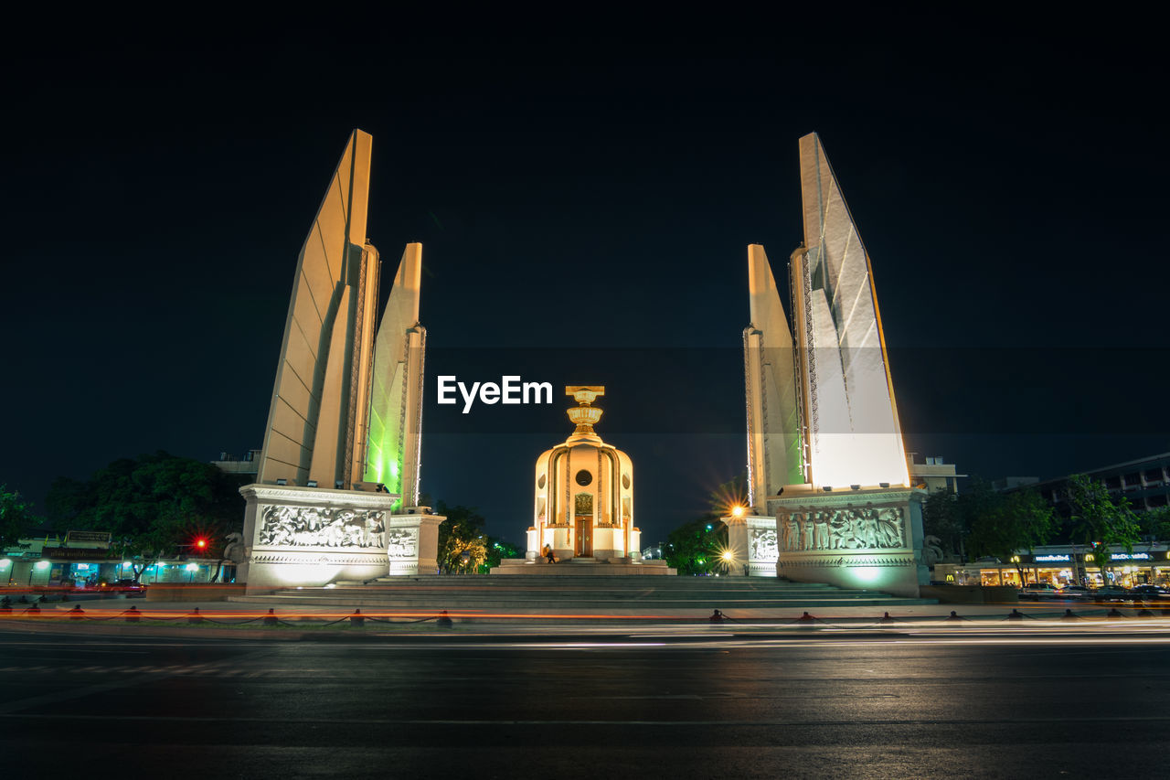 LOW ANGLE VIEW OF ILLUMINATED BUILDING AT NIGHT