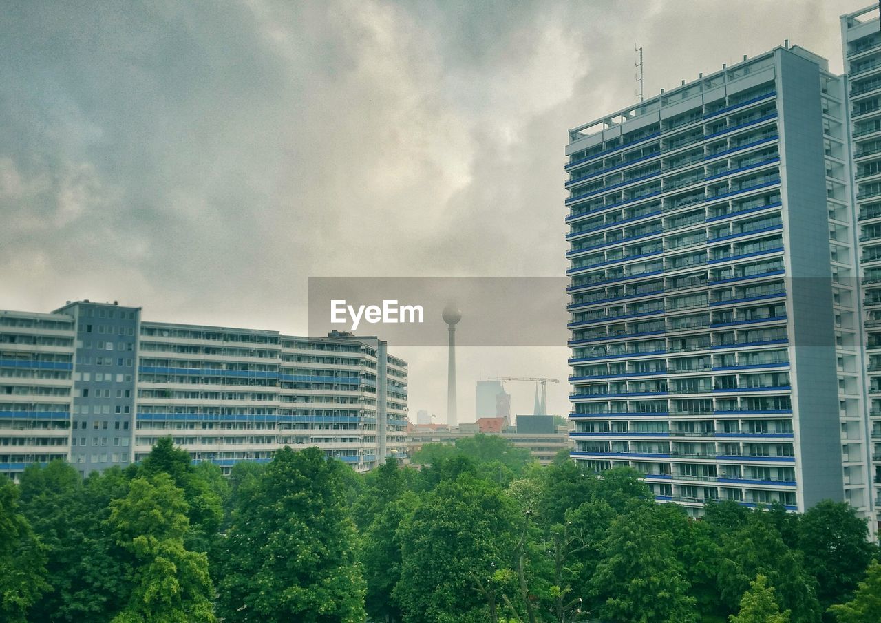 Buildings in city against cloudy sky