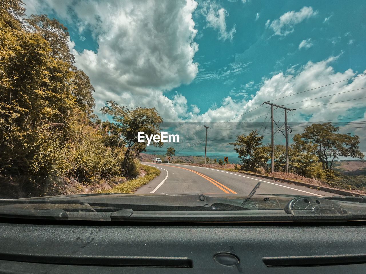 Road against sky seen through car windshield