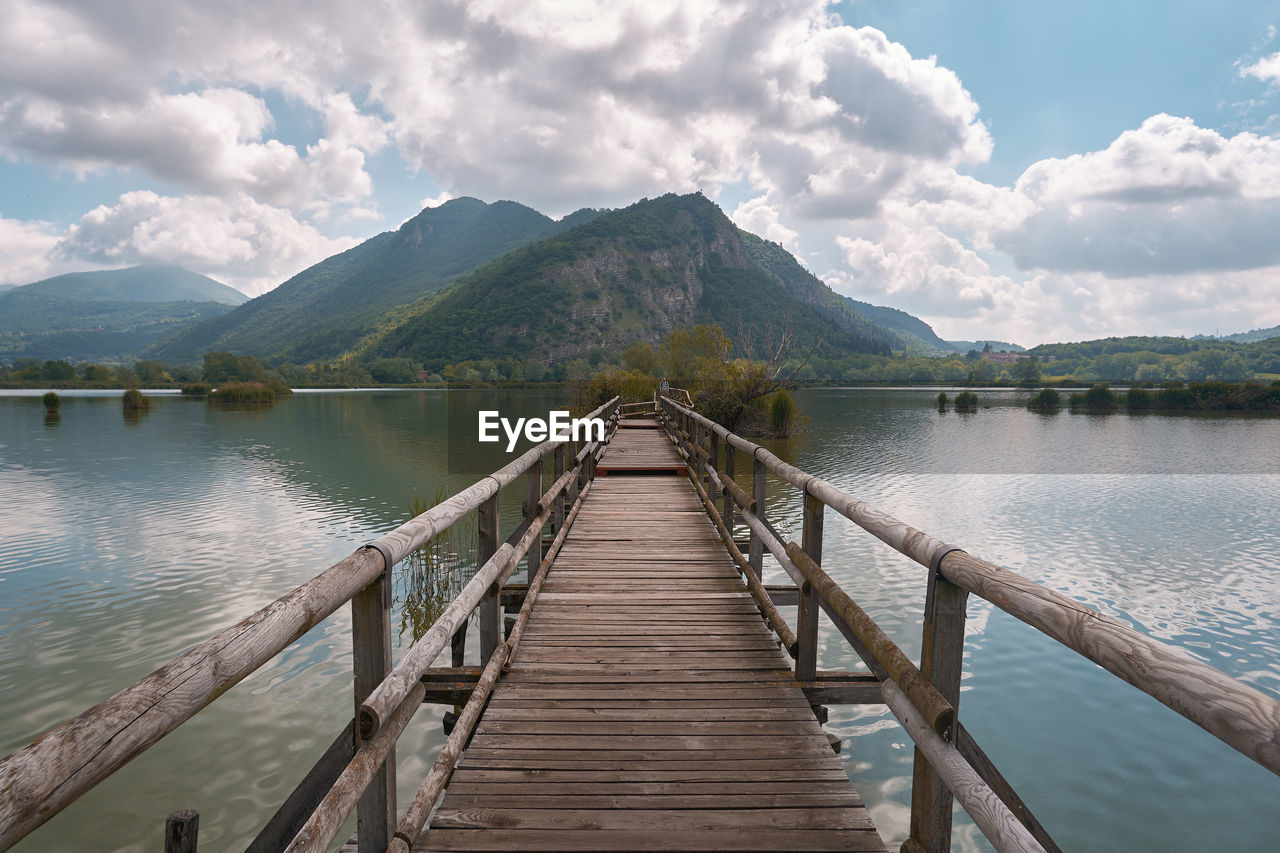 Wooden pier over lake against sky