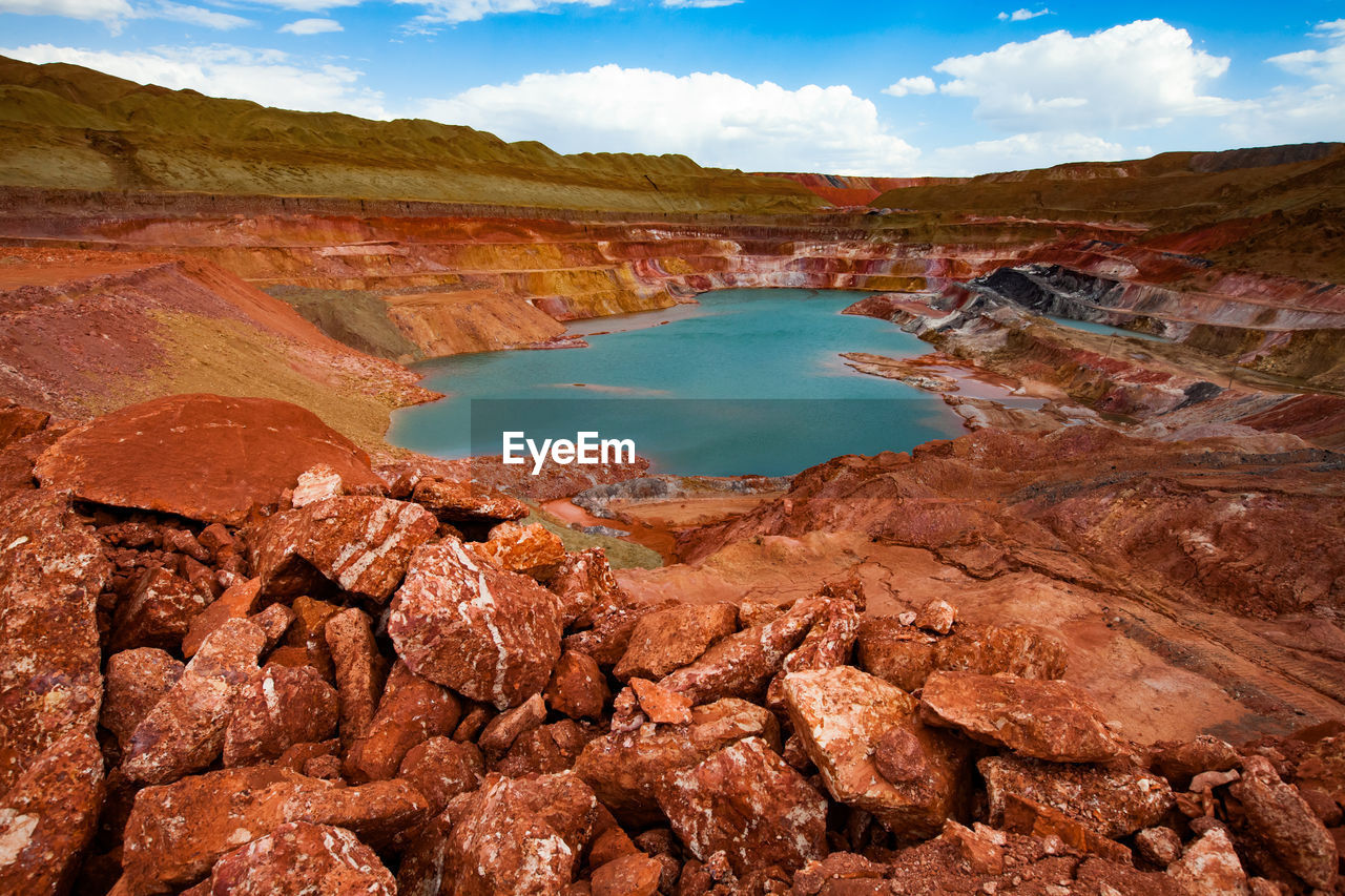 Surrealistic view of bauxite quarry against sky