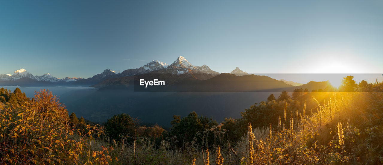 Early lights and late stars over the annapurna mountain range in western nepal