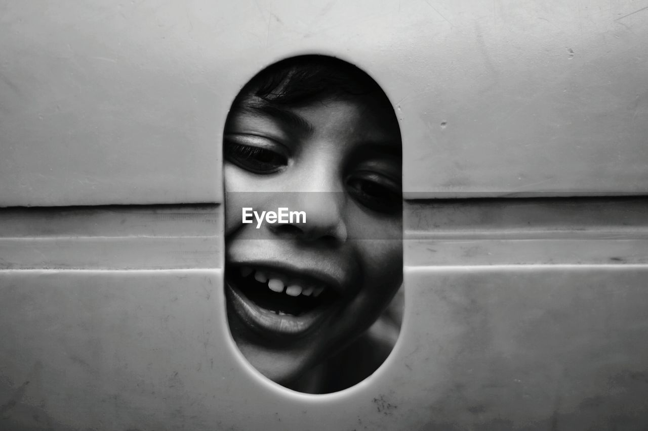 Portrait of smiling boy looking through hole