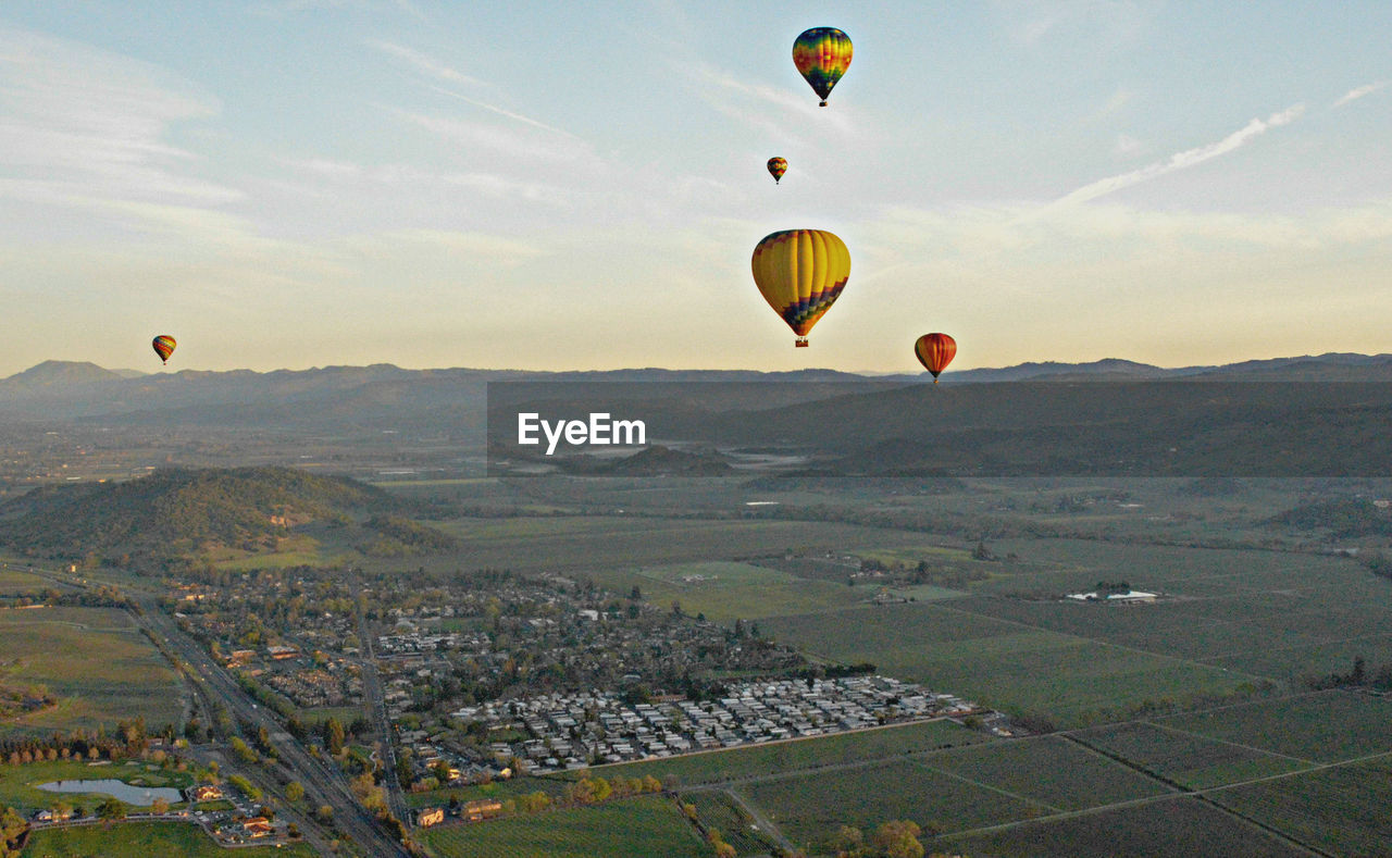 Hot air balloons flying over landscape