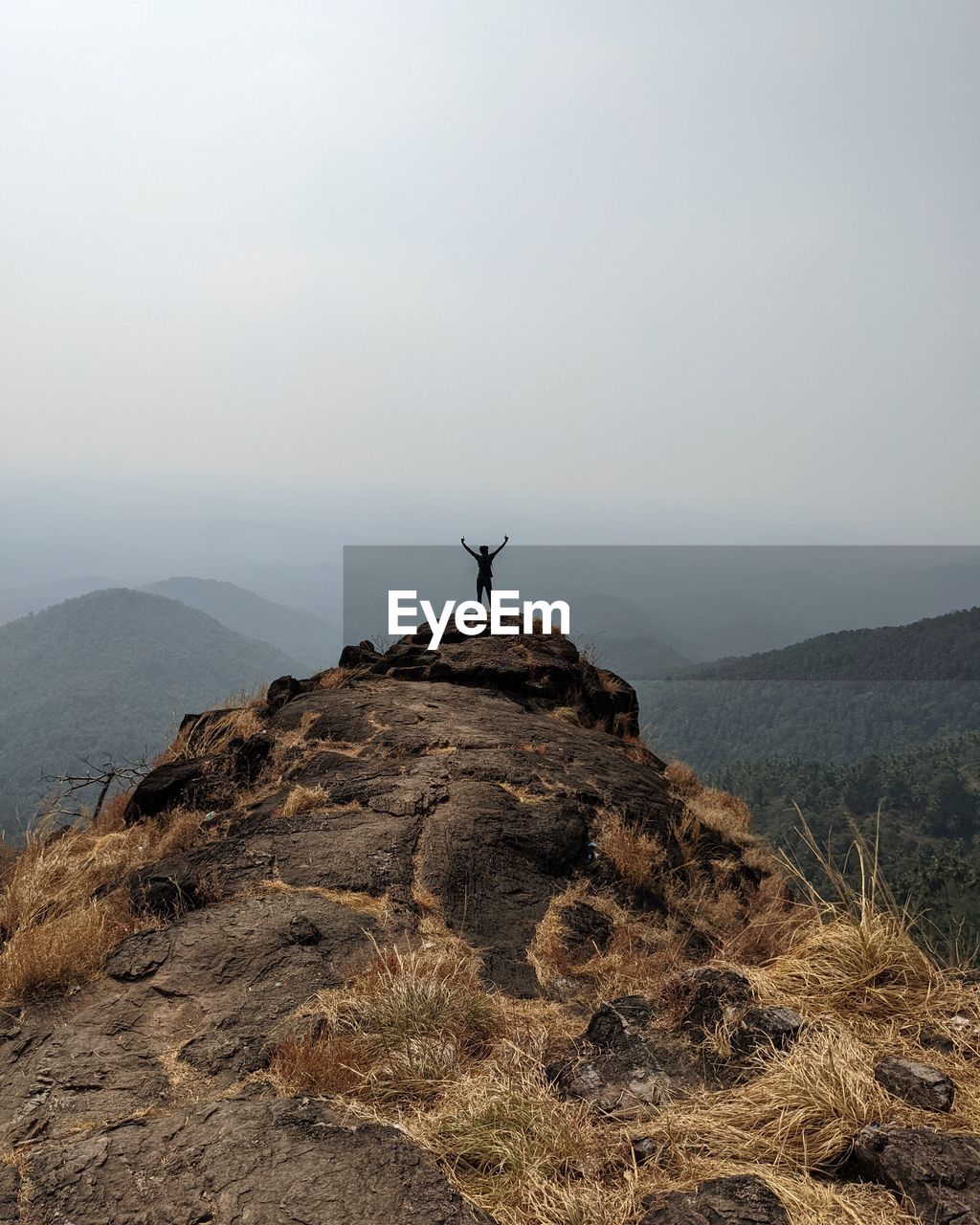 rear view of man walking on mountain against sky