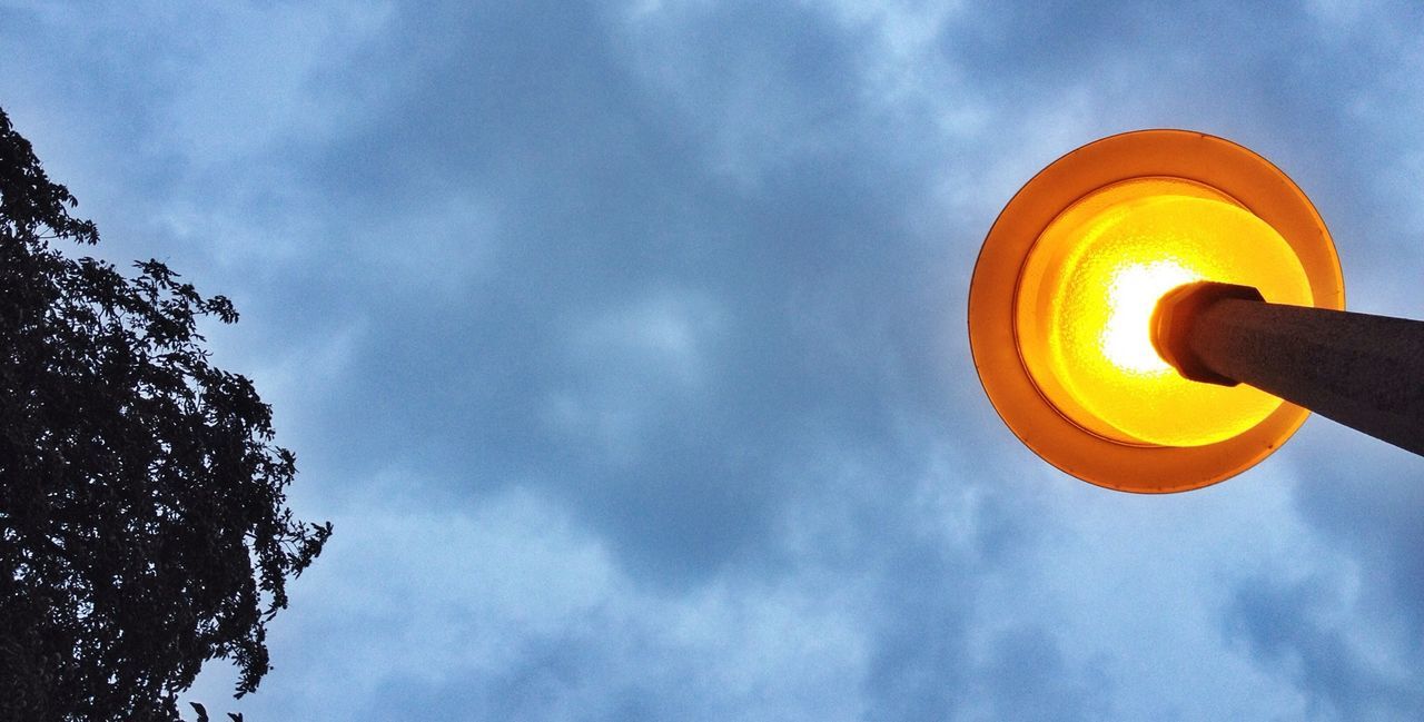 Low angle view of lit lamp post against the sky