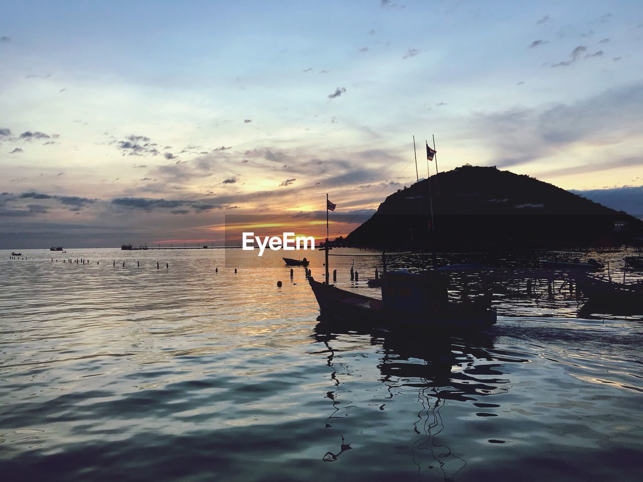 SILHOUETTE BOAT MOORED IN SEA AGAINST SKY DURING SUNSET