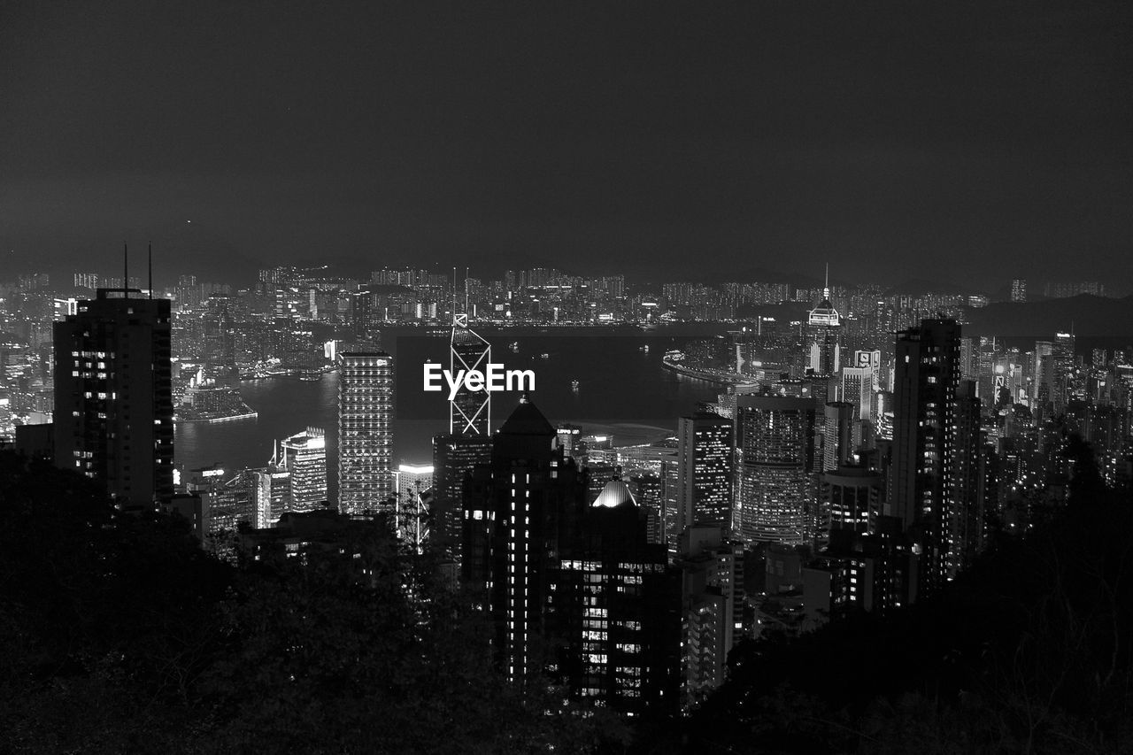 Illuminated buildings in city against sky at night