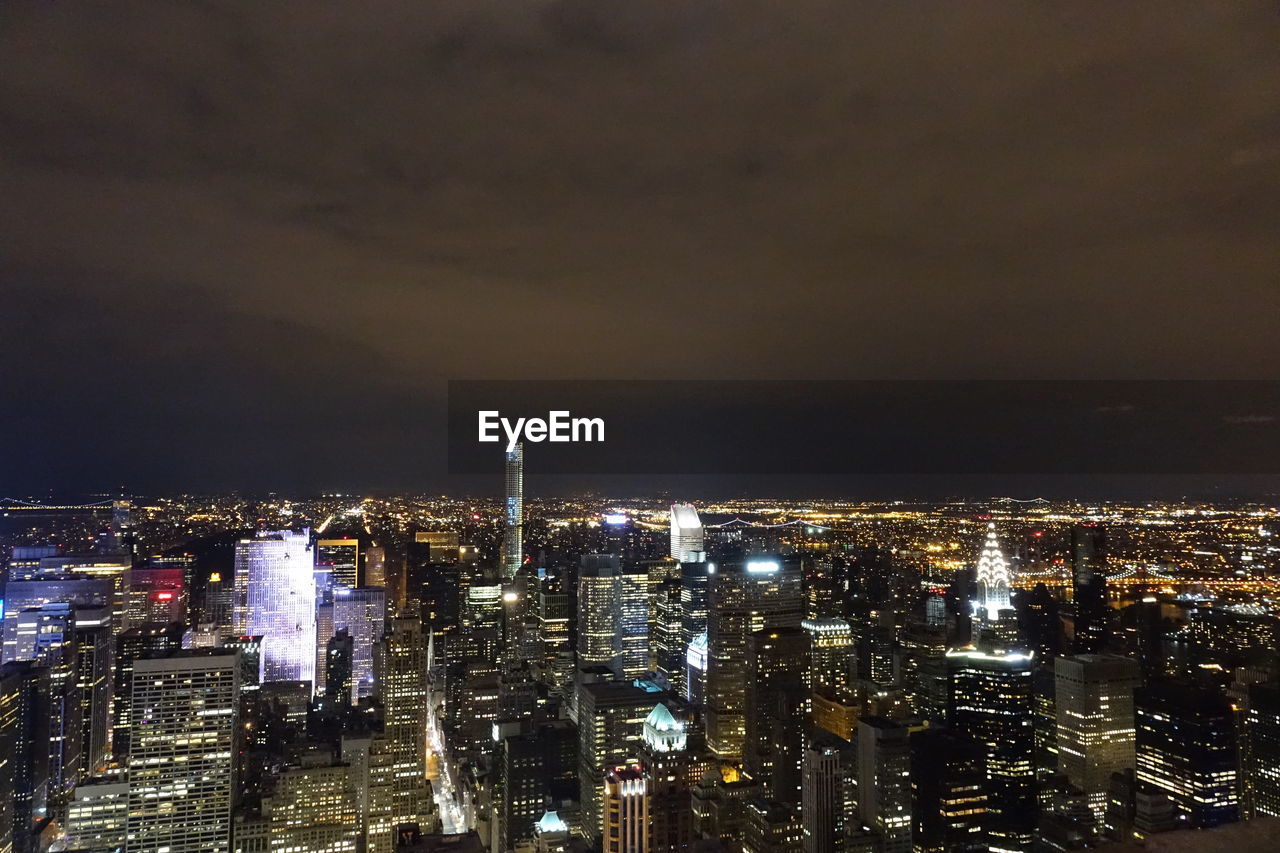 Illuminated cityscape against sky at night