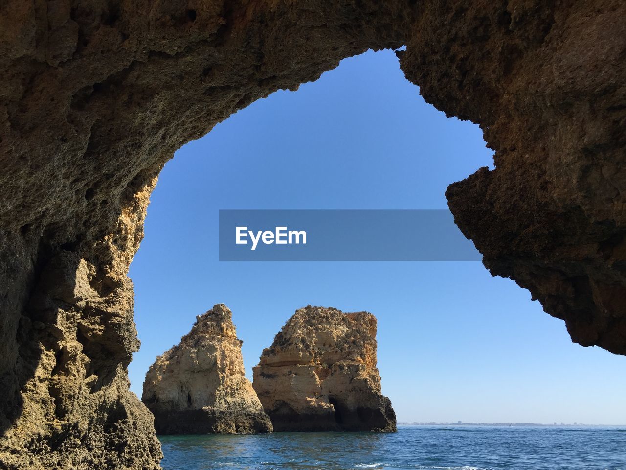 Rock formations in sea against clear sky