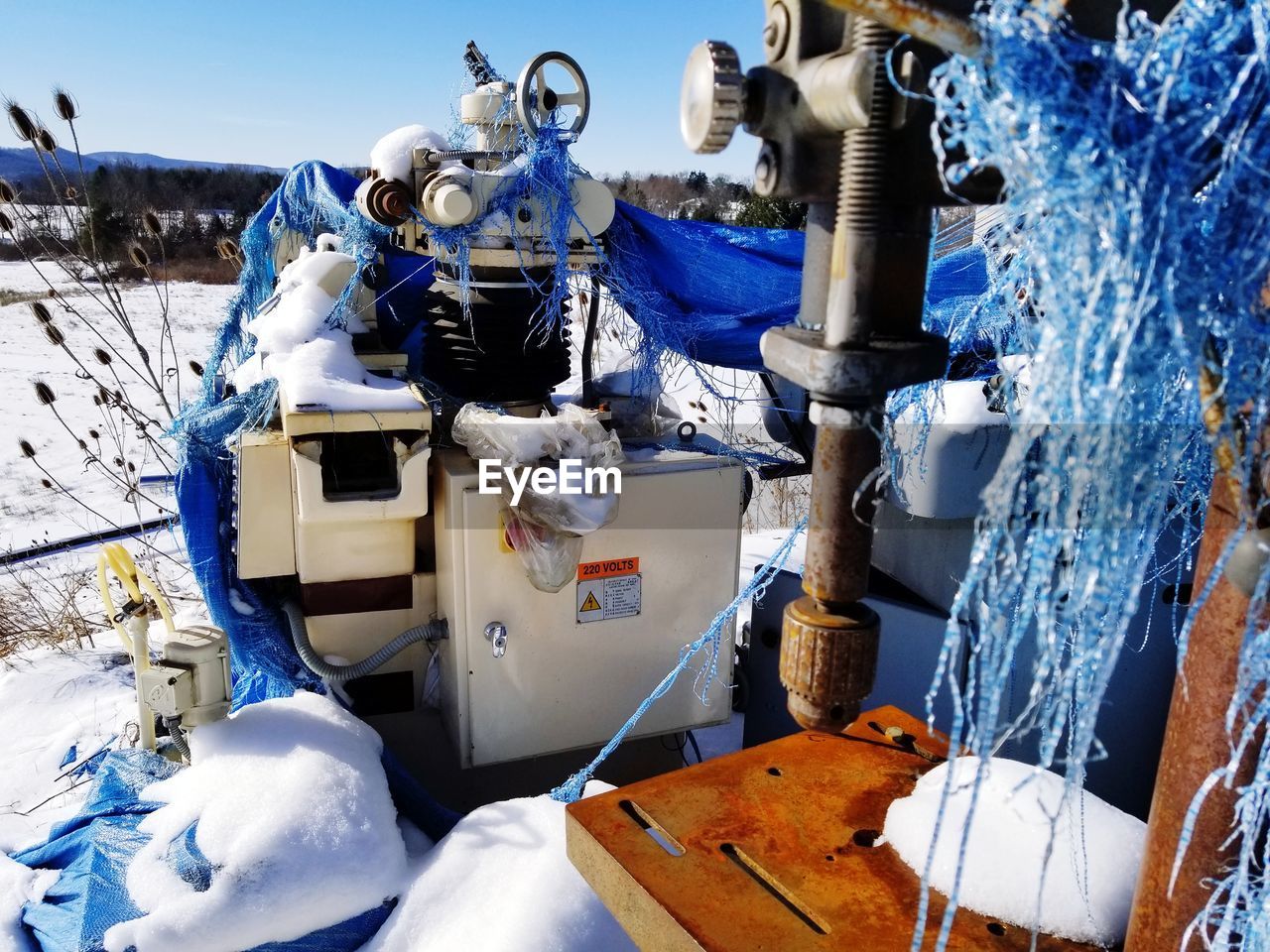 LOW ANGLE VIEW OF MACHINE PART ON SNOW COVERED LANDSCAPE