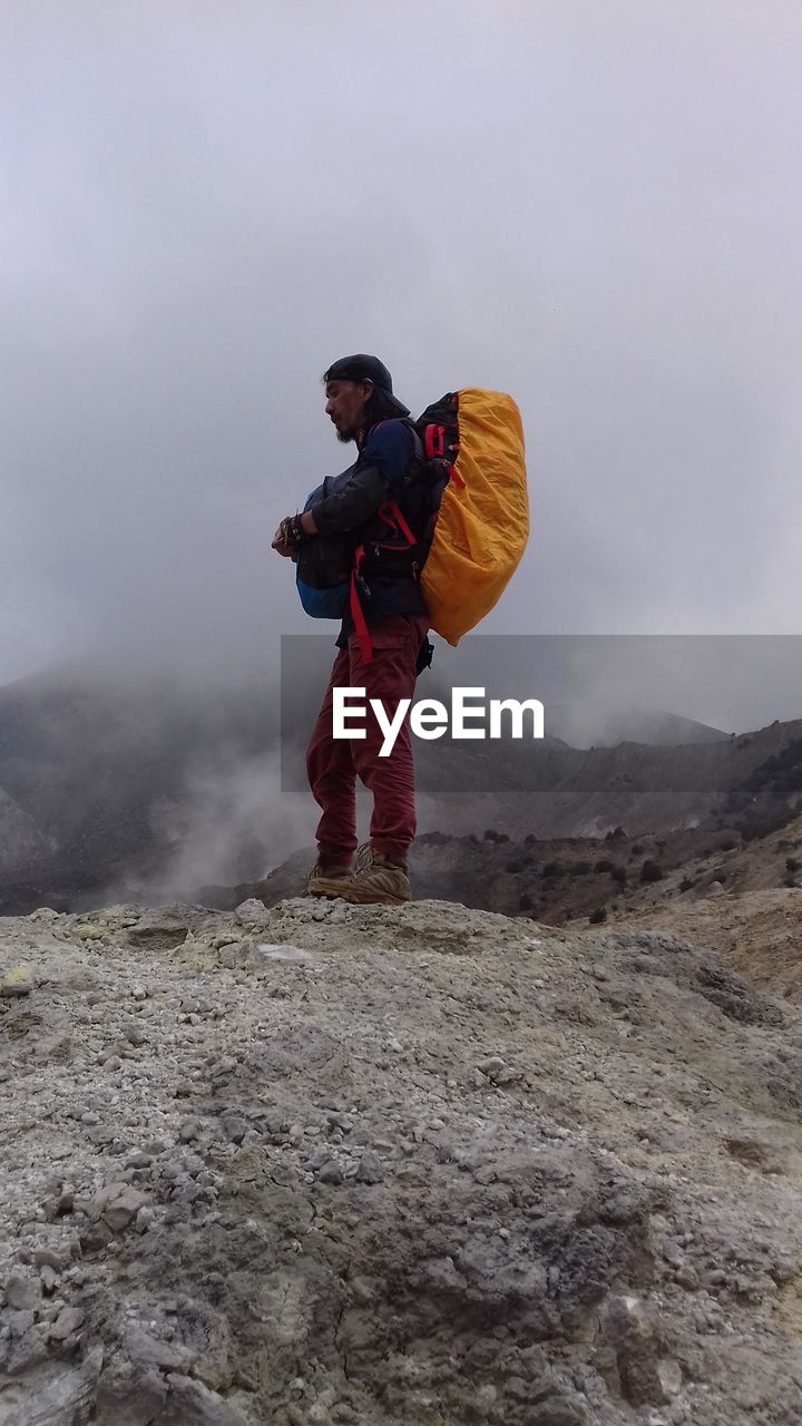 Full length of man standing on mountain against sky