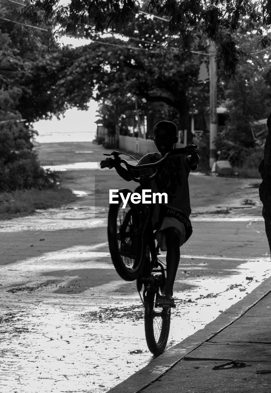 Kid riding bicycle on road