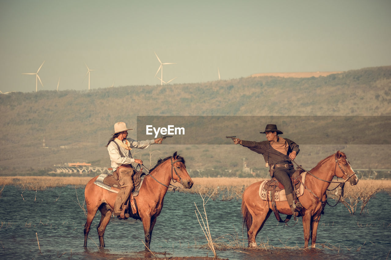 PEOPLE RIDING HORSE IN THE SEA