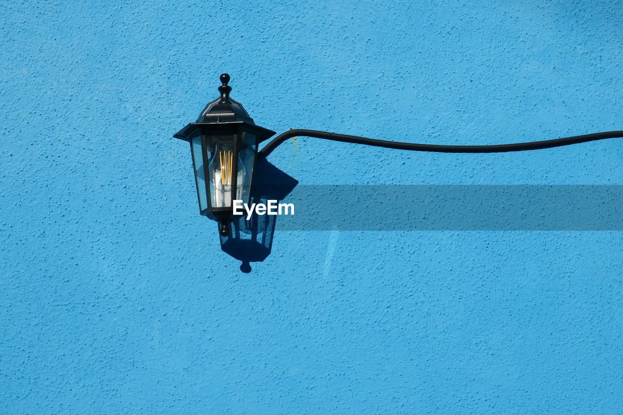 LOW ANGLE VIEW OF LIGHT BULB ON WALL