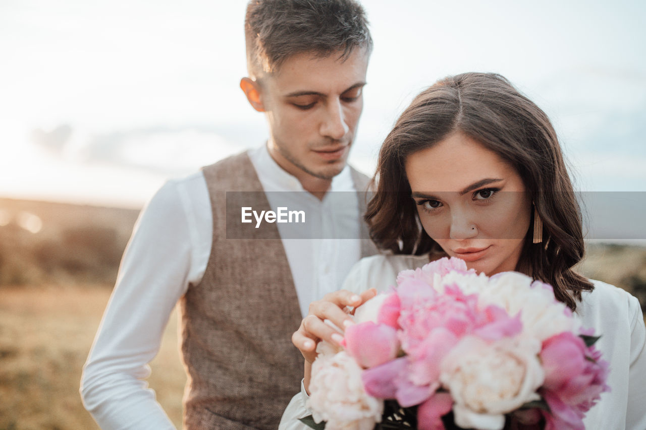 Portrait of young couple with pink flower