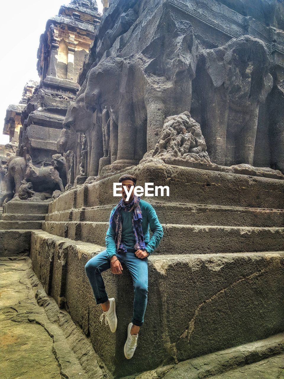 Portrait of man sitting at old ruin