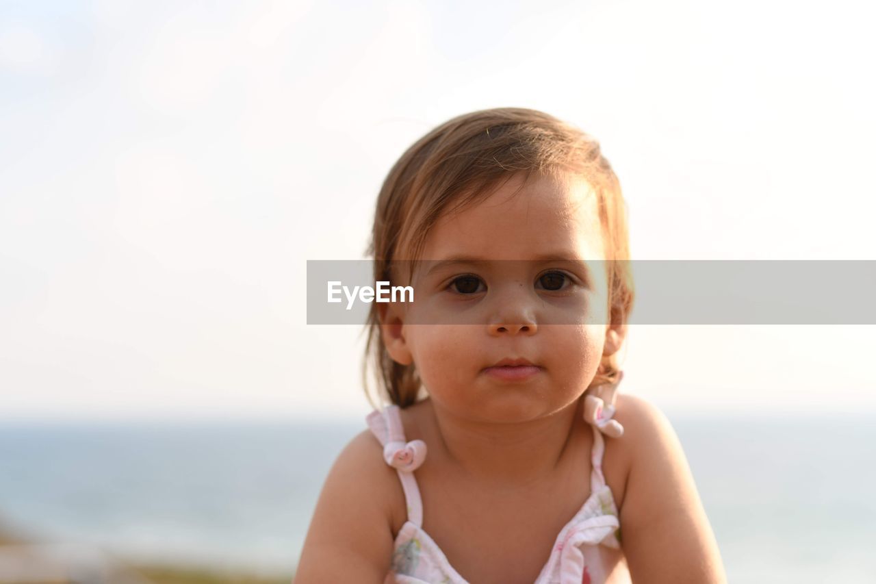 Portrait of cute girl against sky