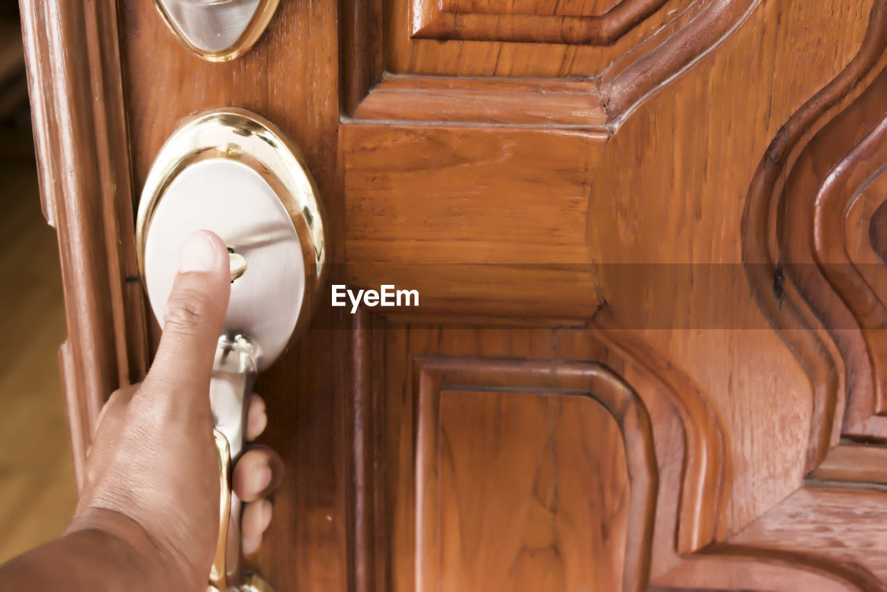 MIDSECTION OF PERSON HOLDING DOOR OF BUILDING