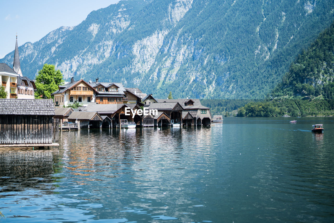 HOUSES BY LAKE AND BUILDINGS AGAINST MOUNTAIN