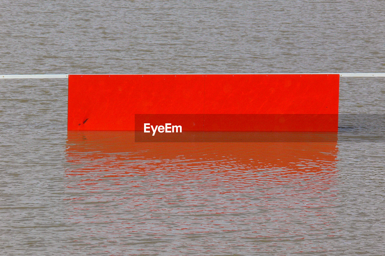 CLOSE-UP OF RED SEA AGAINST ORANGE WALL