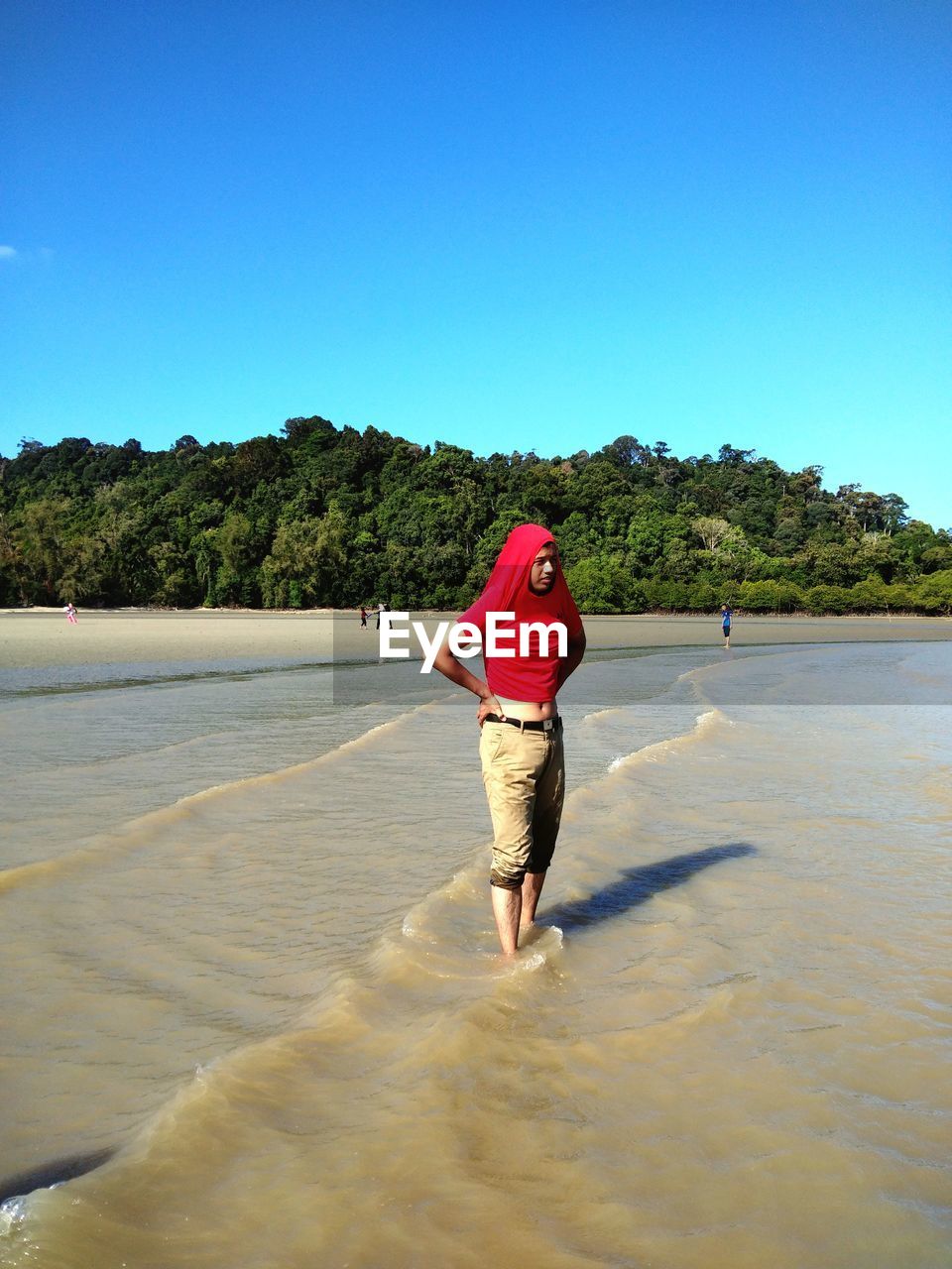 FULL LENGTH REAR VIEW OF MAN STANDING ON BEACH