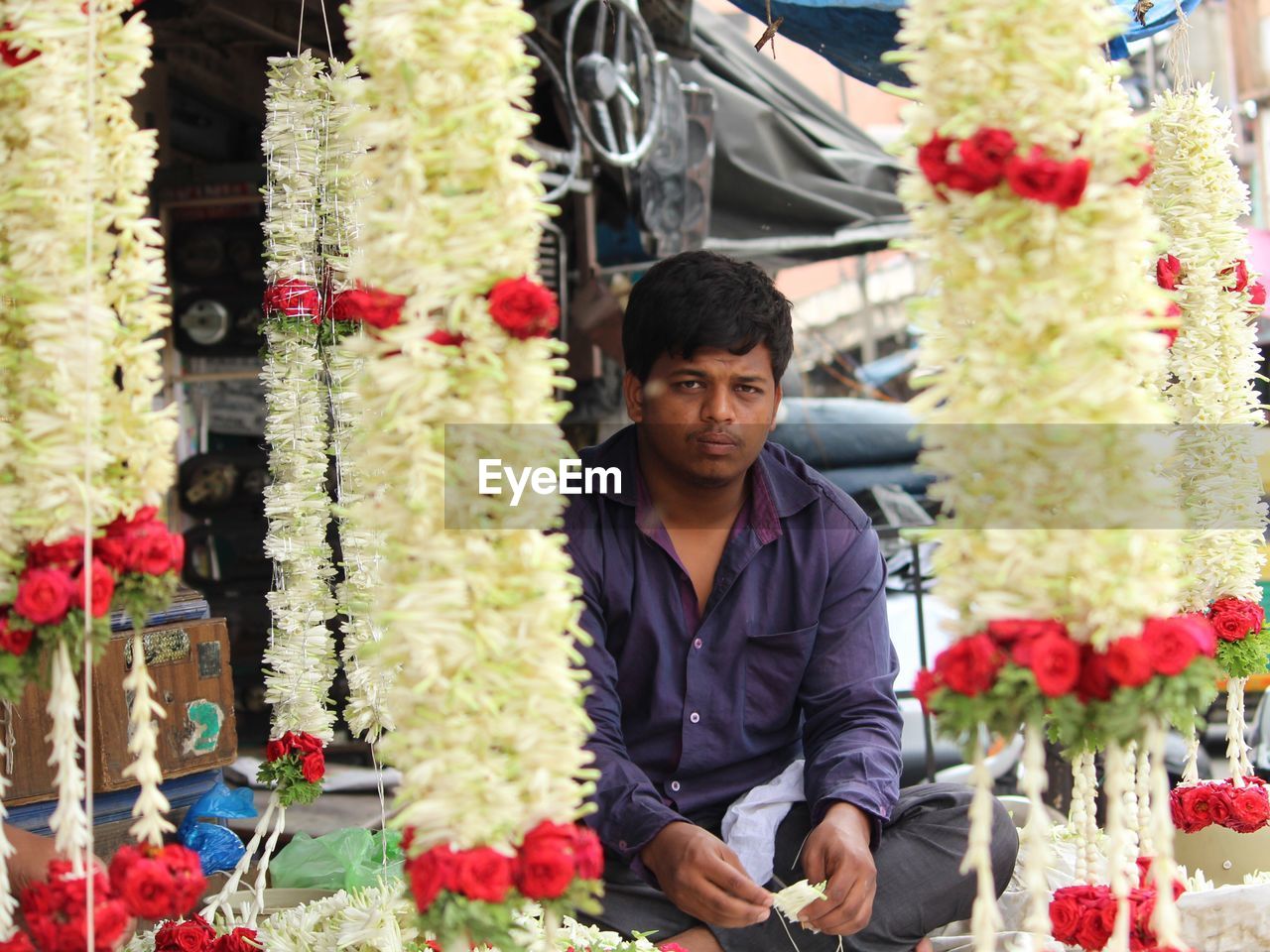 Portrait of vendor selling floral garlands at market