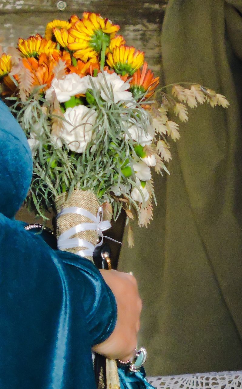 LOW SECTION OF MAN WITH FLOWERS AND LEAVES