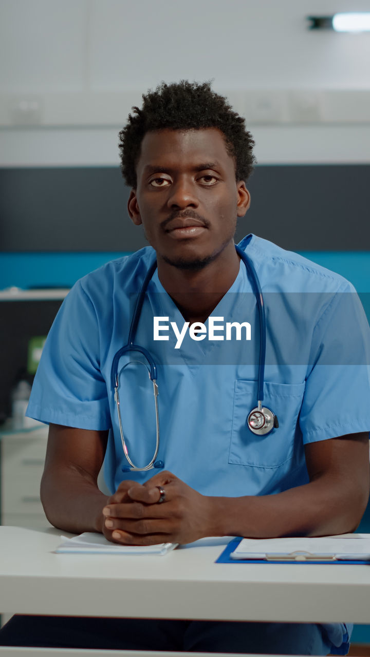 Portrait of young doctor sitting at hospital