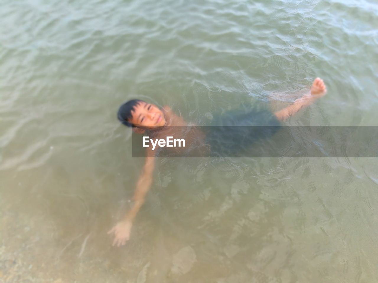 PORTRAIT OF WOMAN SWIMMING IN SEA