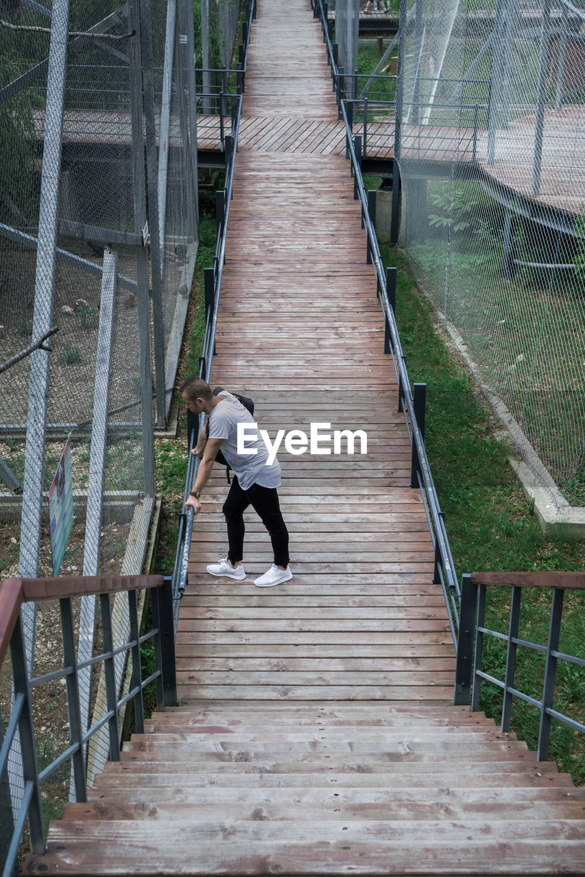 Full length of man standing on footbridge