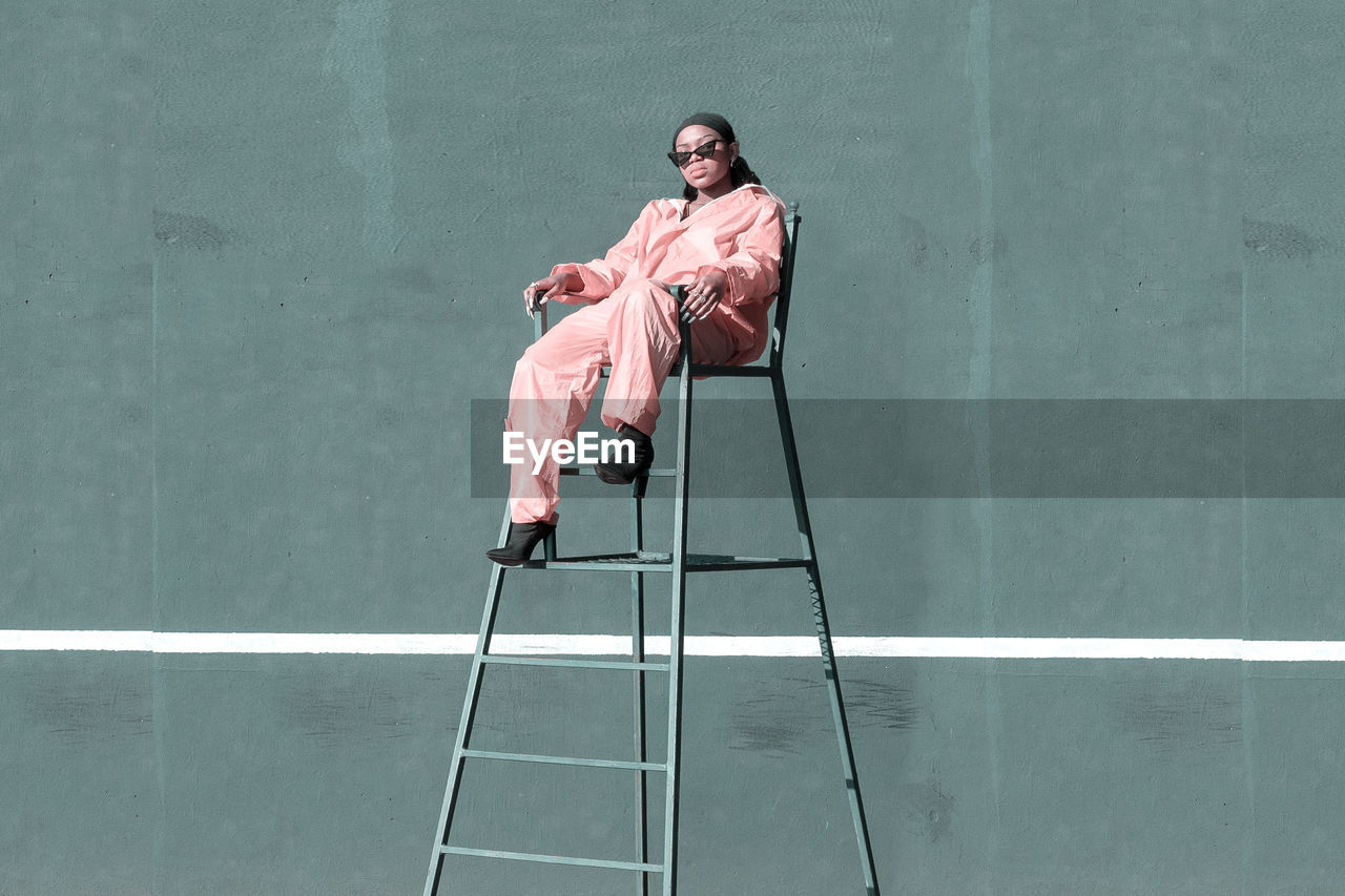 Portrait of girl sitting on chair in court