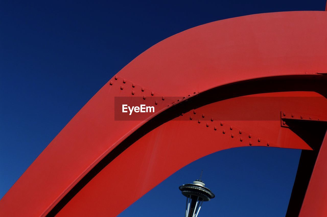 Low angle view of red metallic structure against clear blue sky