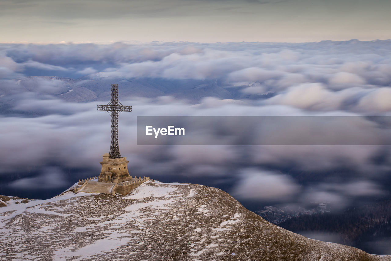 Communications tower against cloudy sky