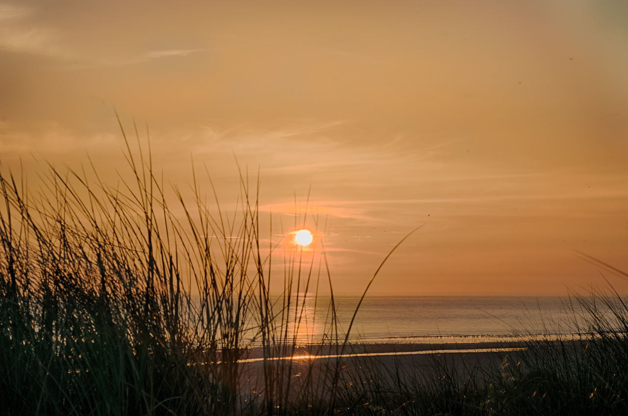 SCENIC VIEW OF SUNSET OVER LAND AND SEA