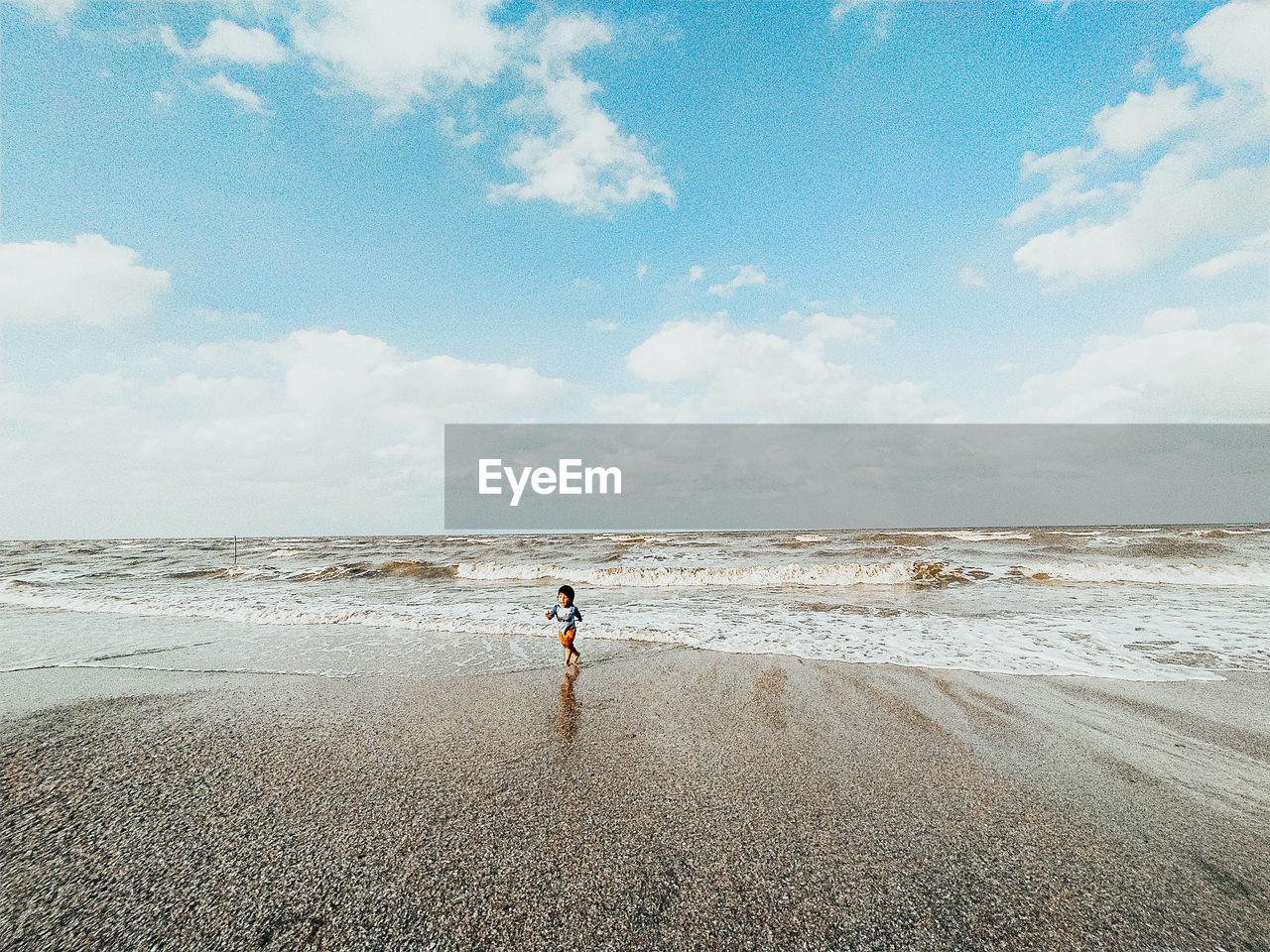 MAN ON BEACH AGAINST SKY