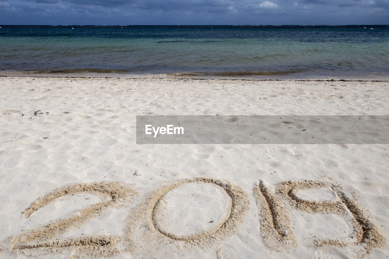 TEXT ON BEACH AGAINST SKY